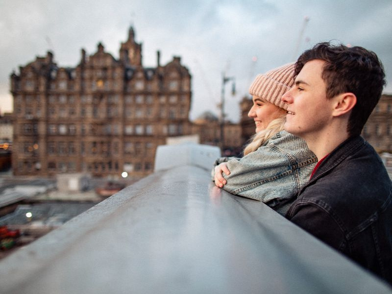 Young people look out across the Edinburgh skyline